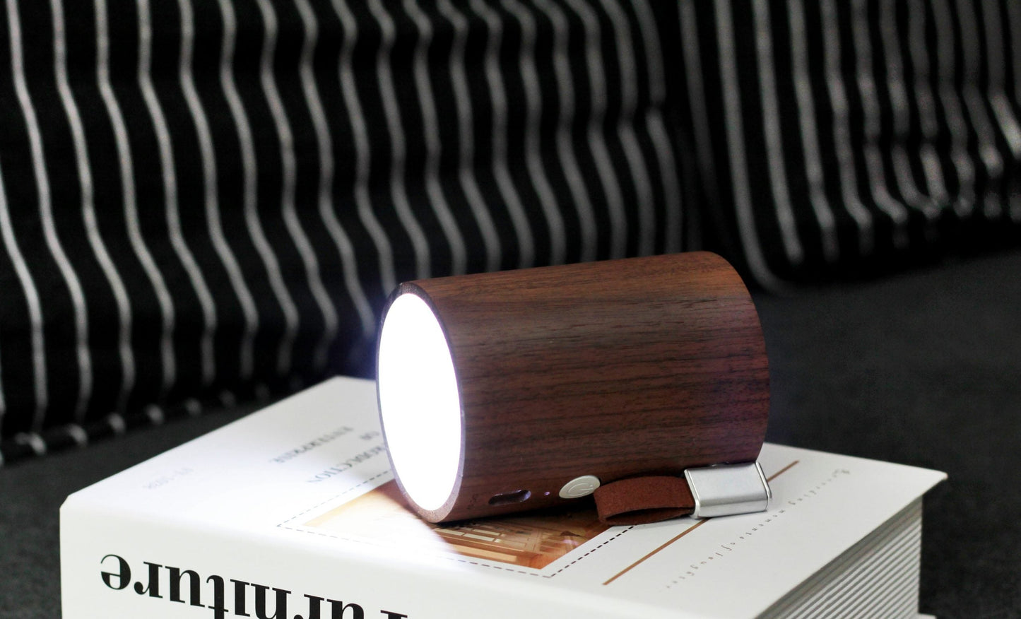Walnut wood drum speaker showing built-in light glow from the top opening