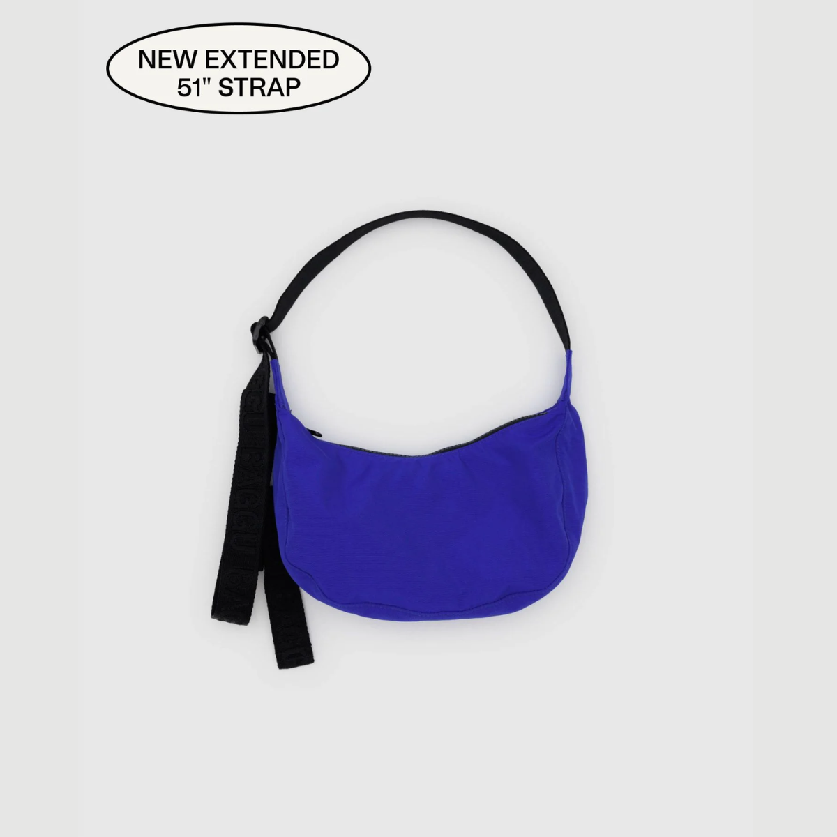 Small crescent nylon crossbody bag in cobalt blue with top strap and hanging tag