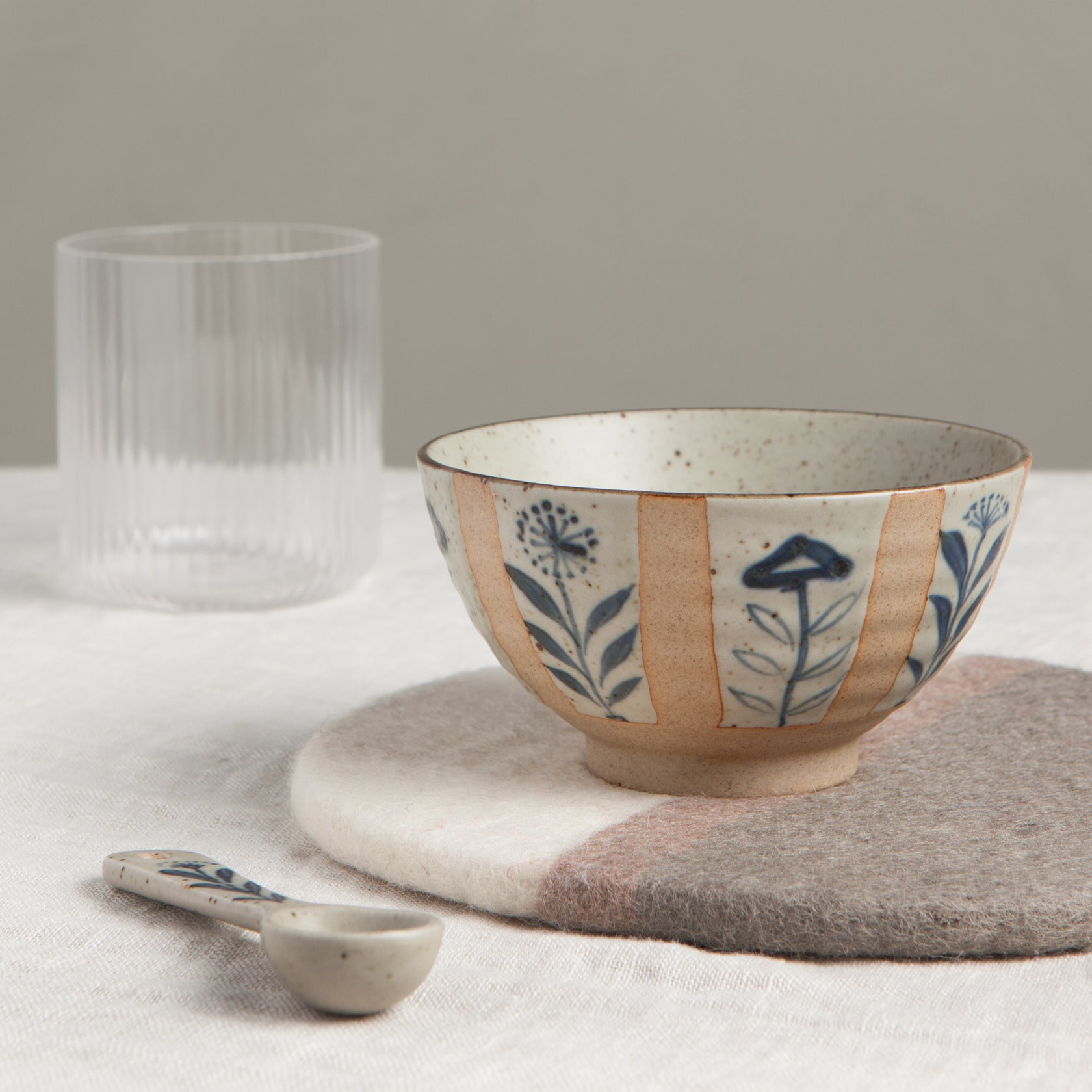 Small ceramic bowl in beige with blue floral sprig motif and band details