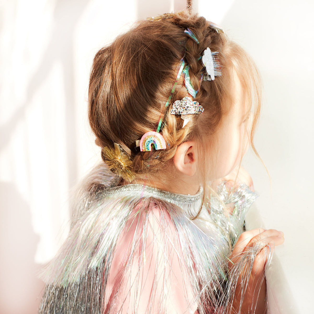 Sparkly weather hair clips in child's hair: rainbow and glitter cloud/sun designs.