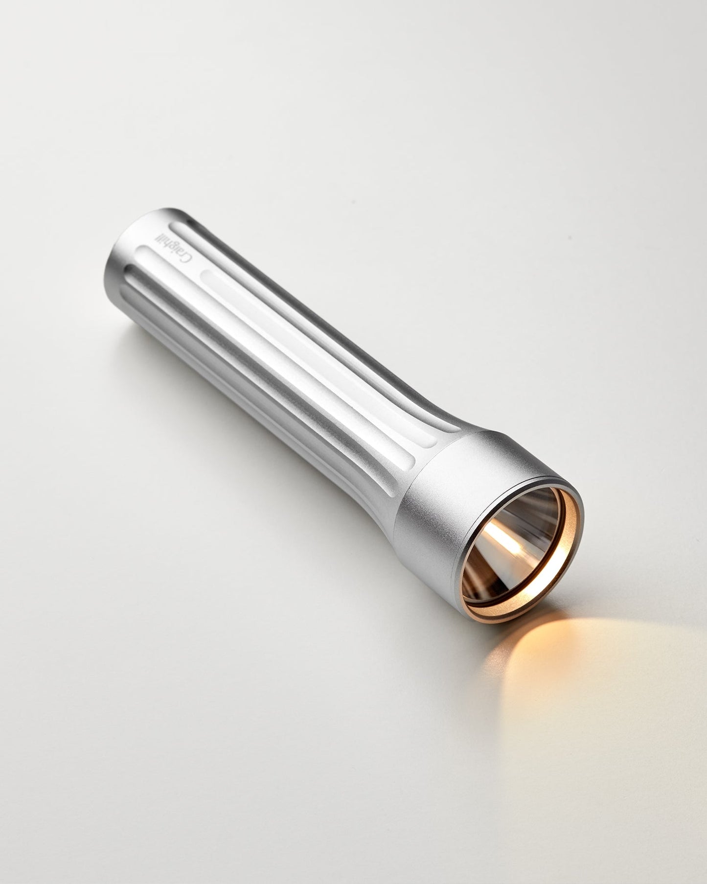 Temple silver flashlight with textured grip and wide beam head