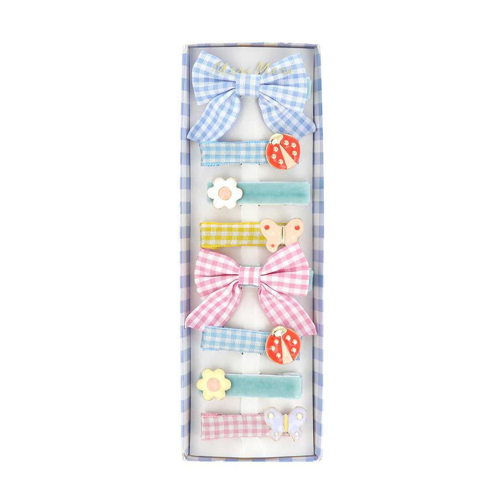 Assorted garden-themed hair clips with blue and pink bows, ladybug and flower shapes