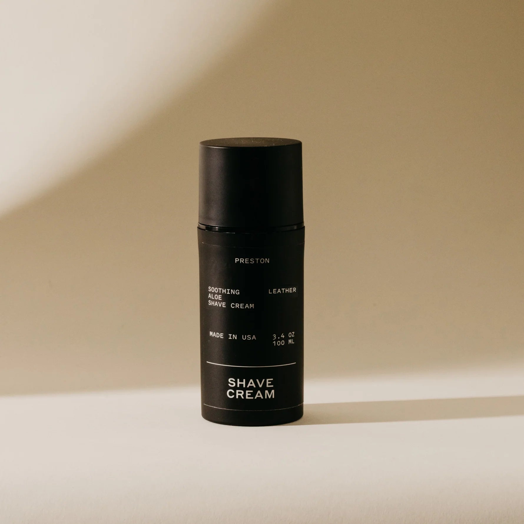 Leather shave cream bottle in black with pump top, labeled Preston