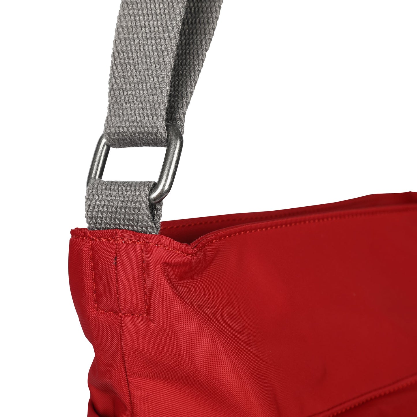 Red nylon crossbody bag with gray webbing strap and metal D-ring