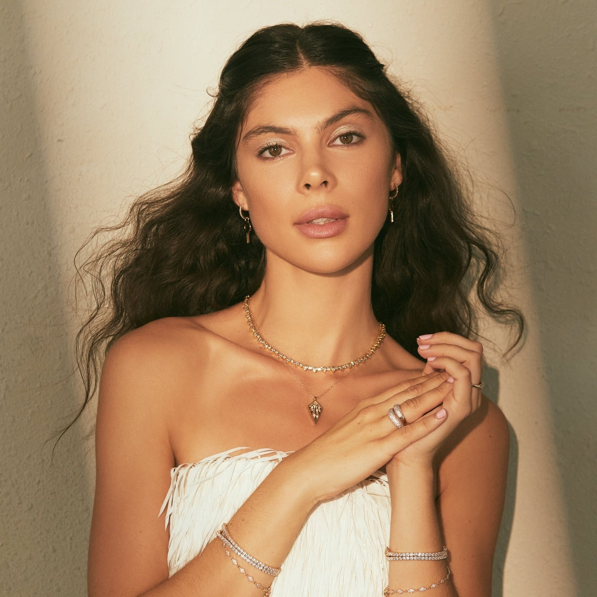 Gold-tone teardrop tennis necklace with clear teardrop stones, front on model.