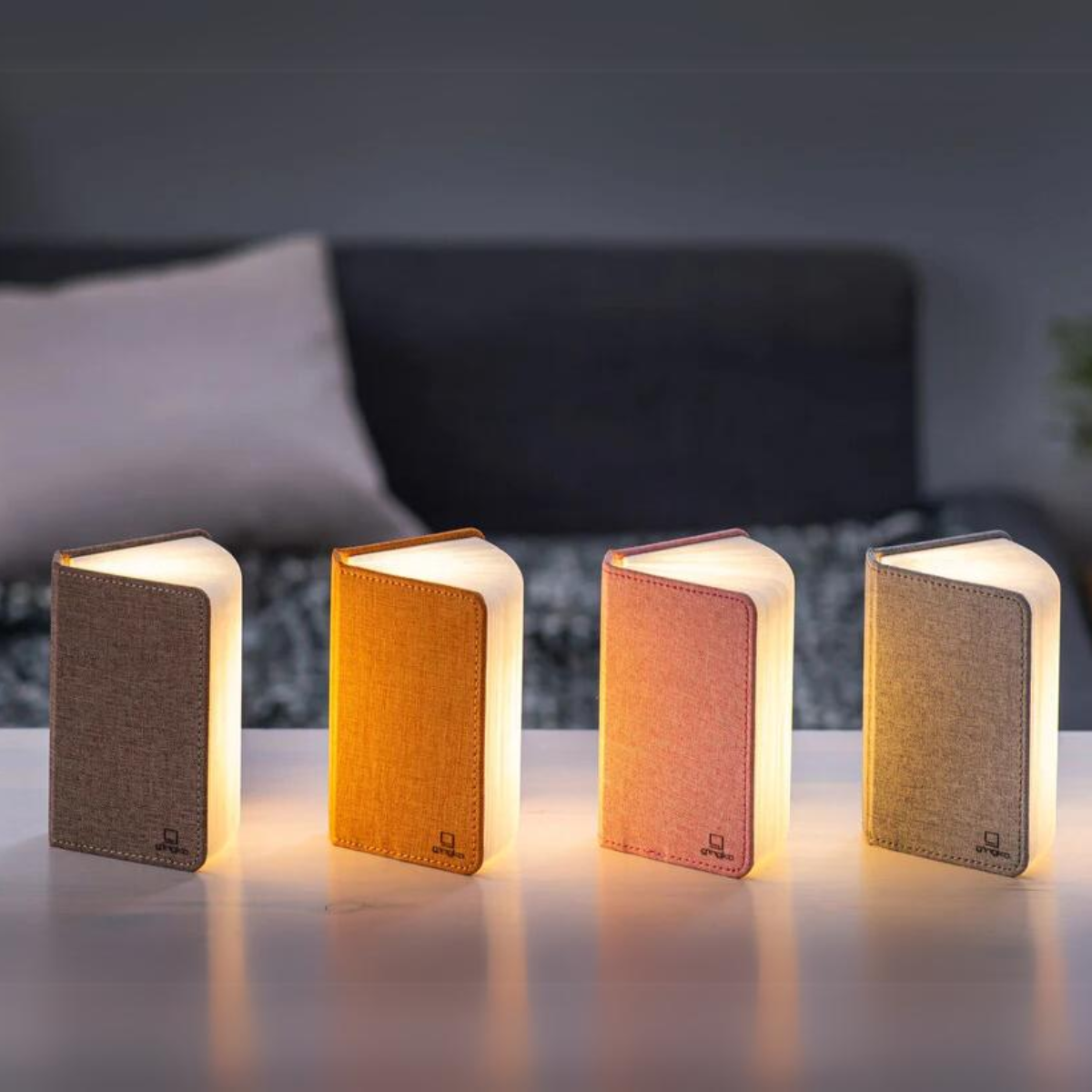 Four mini linen smart booklights in dark, orange, blush pink, and gray colors