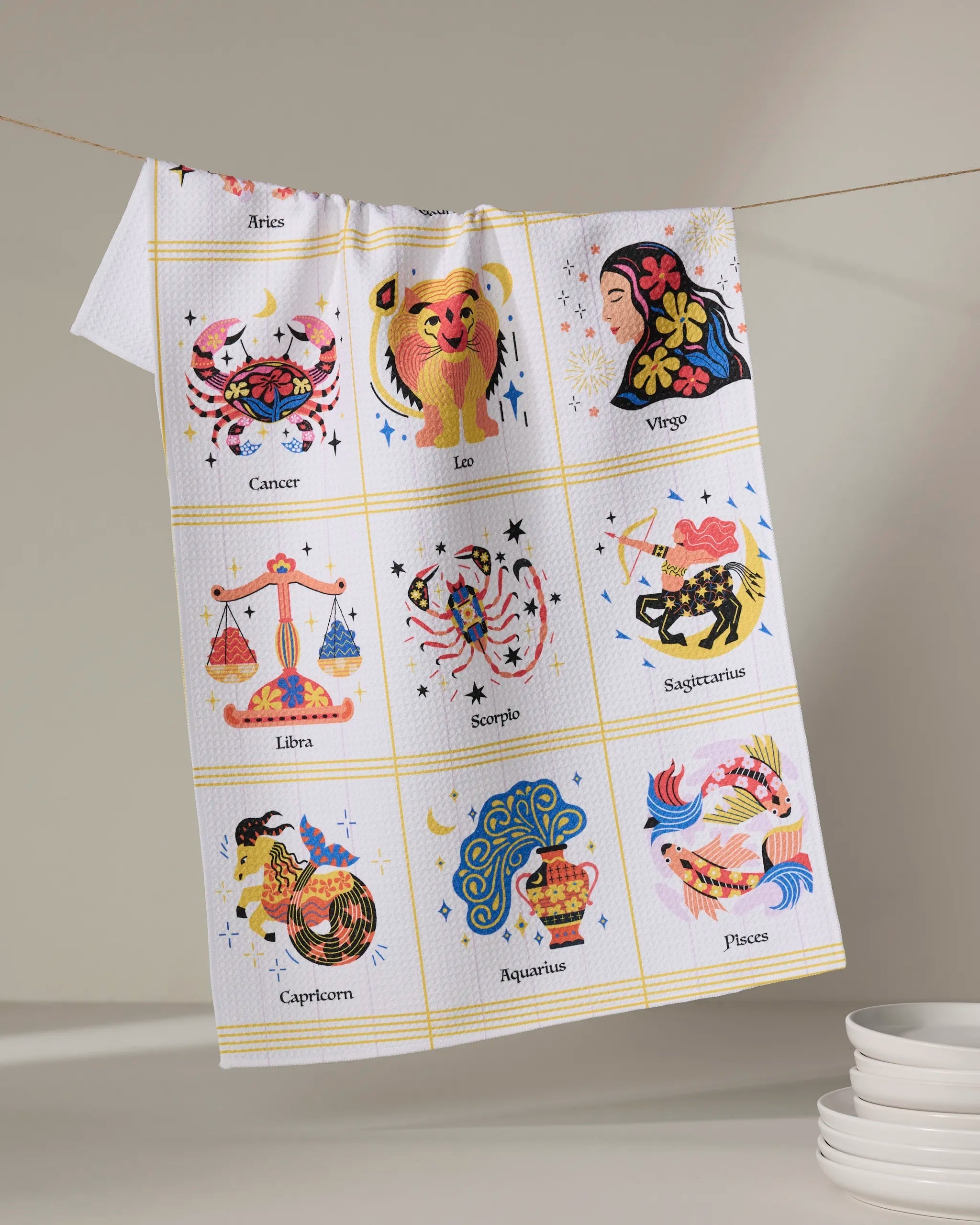 Cosmic zodiac geometry kitchen tea towel with colorful astrology icons and gold grid lines