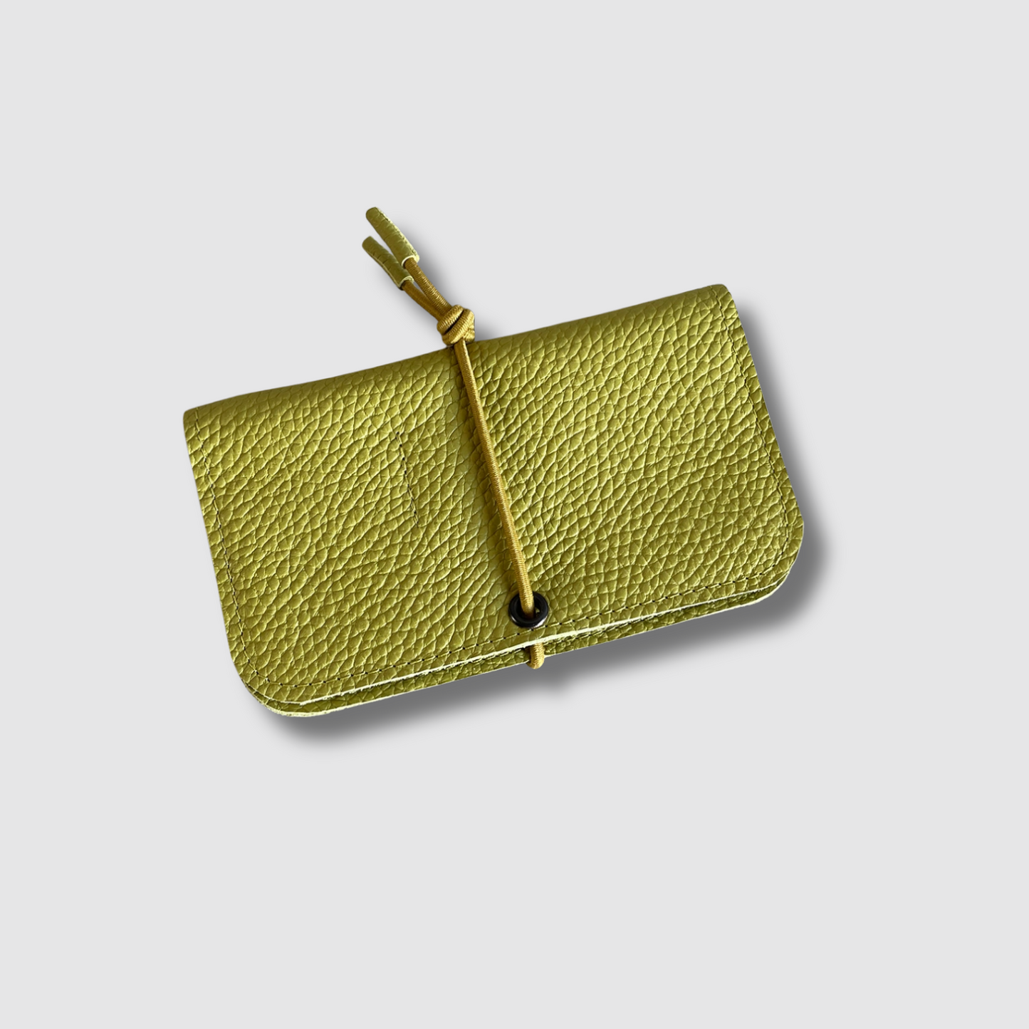 Pistachio green leather knot wallet with front flap and olive cord tie, textured leather