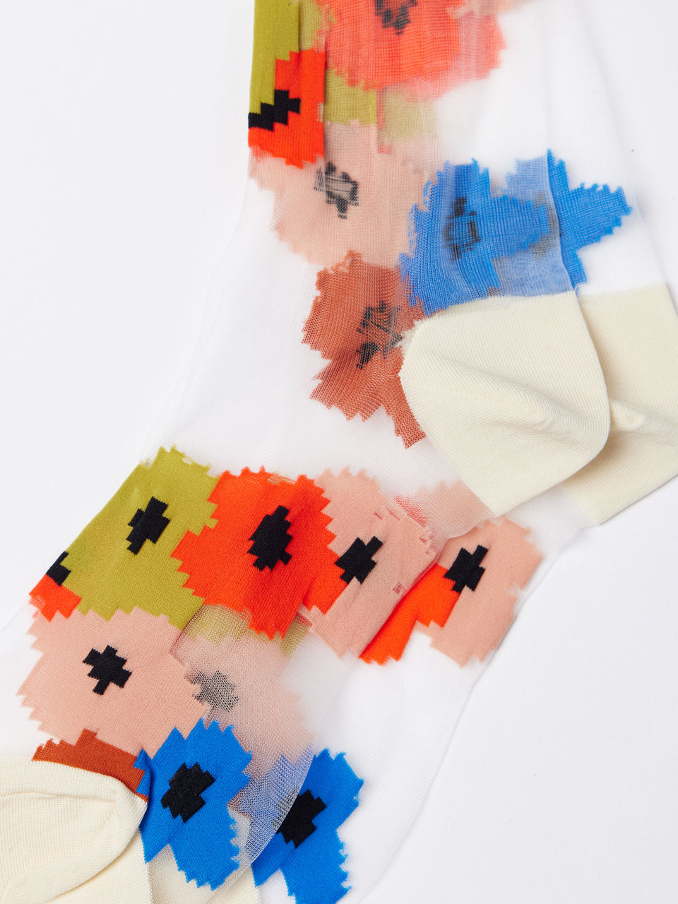 White sheer crew socks close-up with orange, blue, and red pixel floral pattern