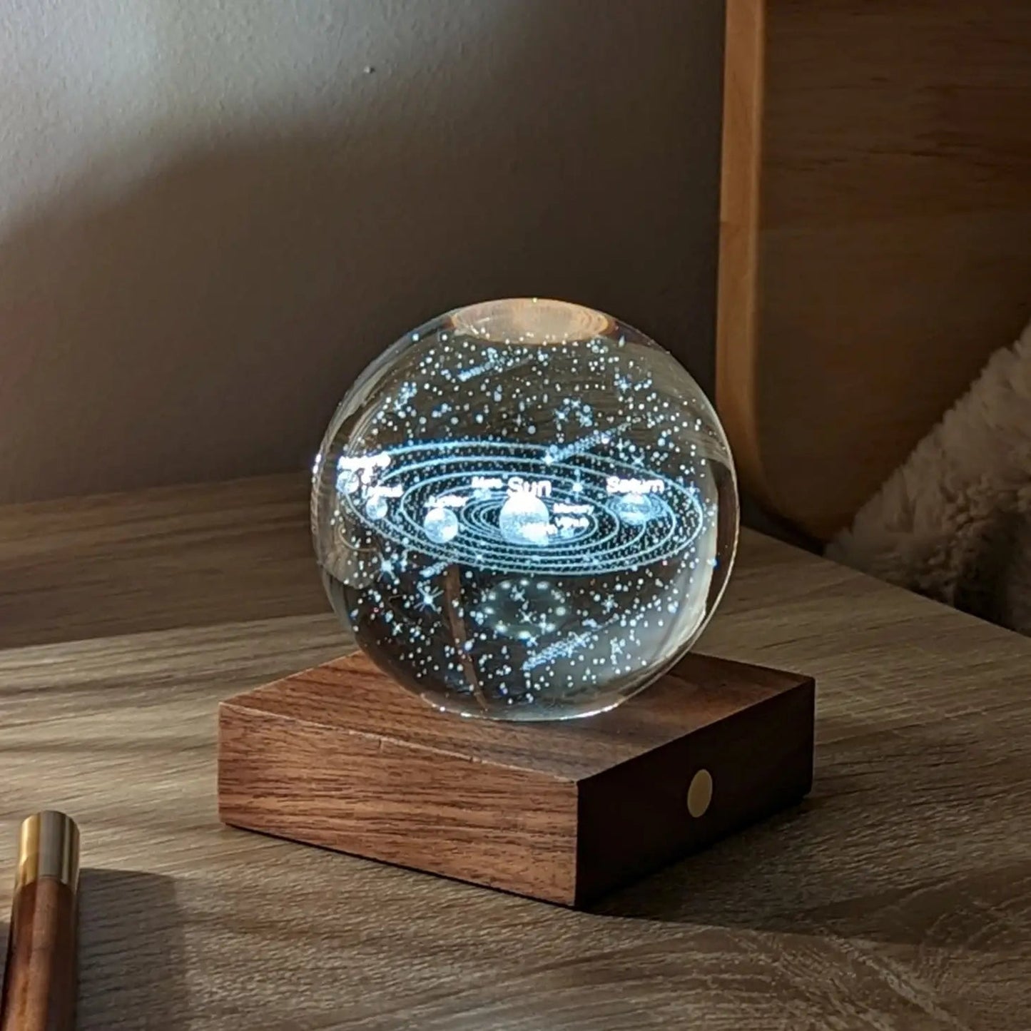 Starry solar system crystal globe night light on dark wood base with round button