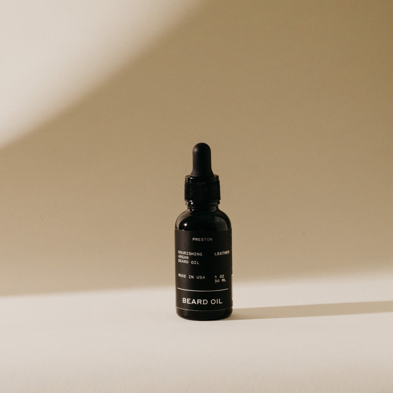 Dark amber beard oil bottle with black dropper cap and label