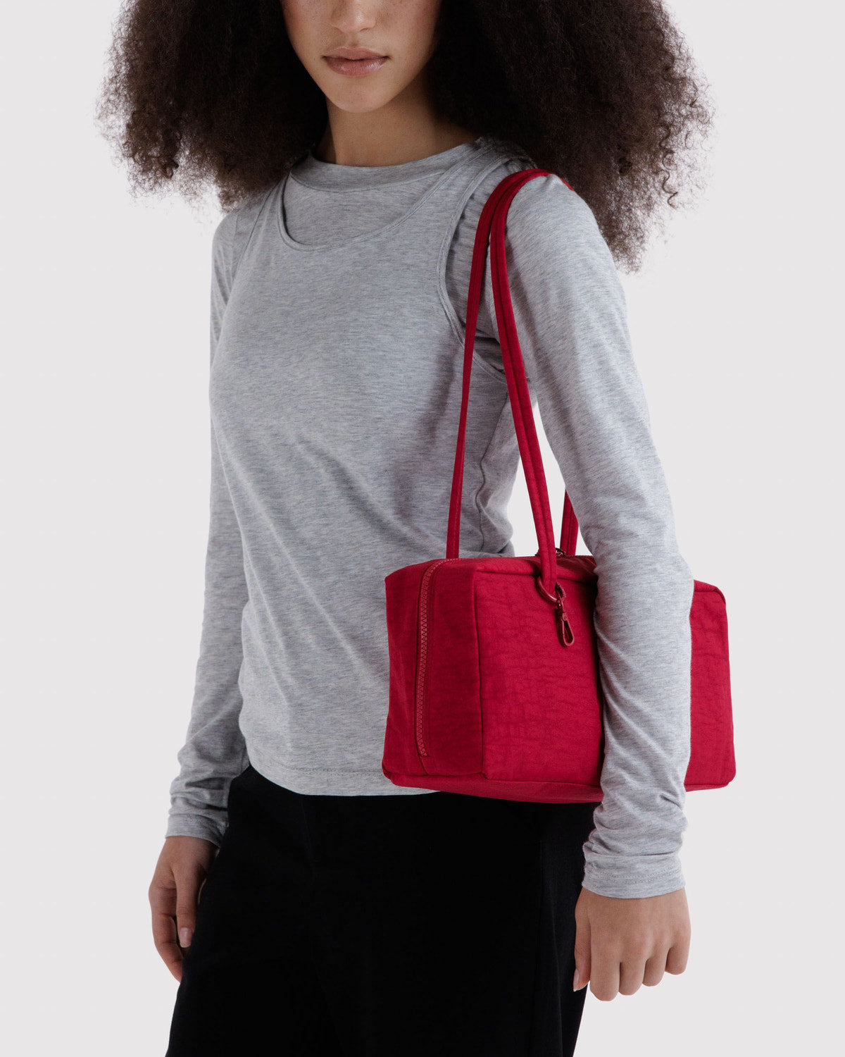 Red nylon bowler bag with top handles and zip front pocket