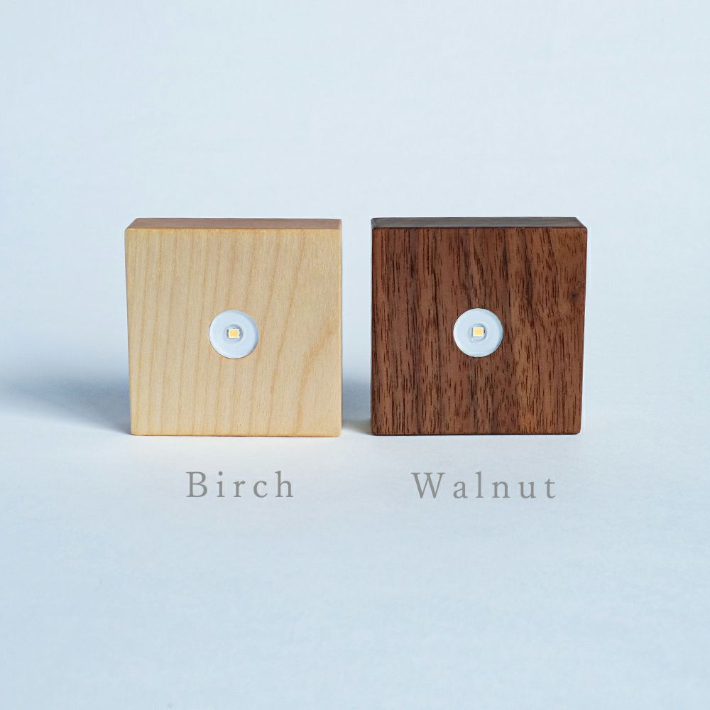 Birch and walnut wood cube light bases with round LED buttons