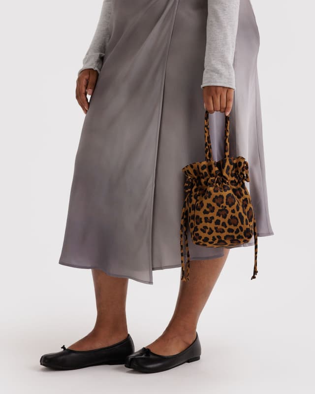 Leopard print nylon drawstring bag with black drawstring ties and handle strap