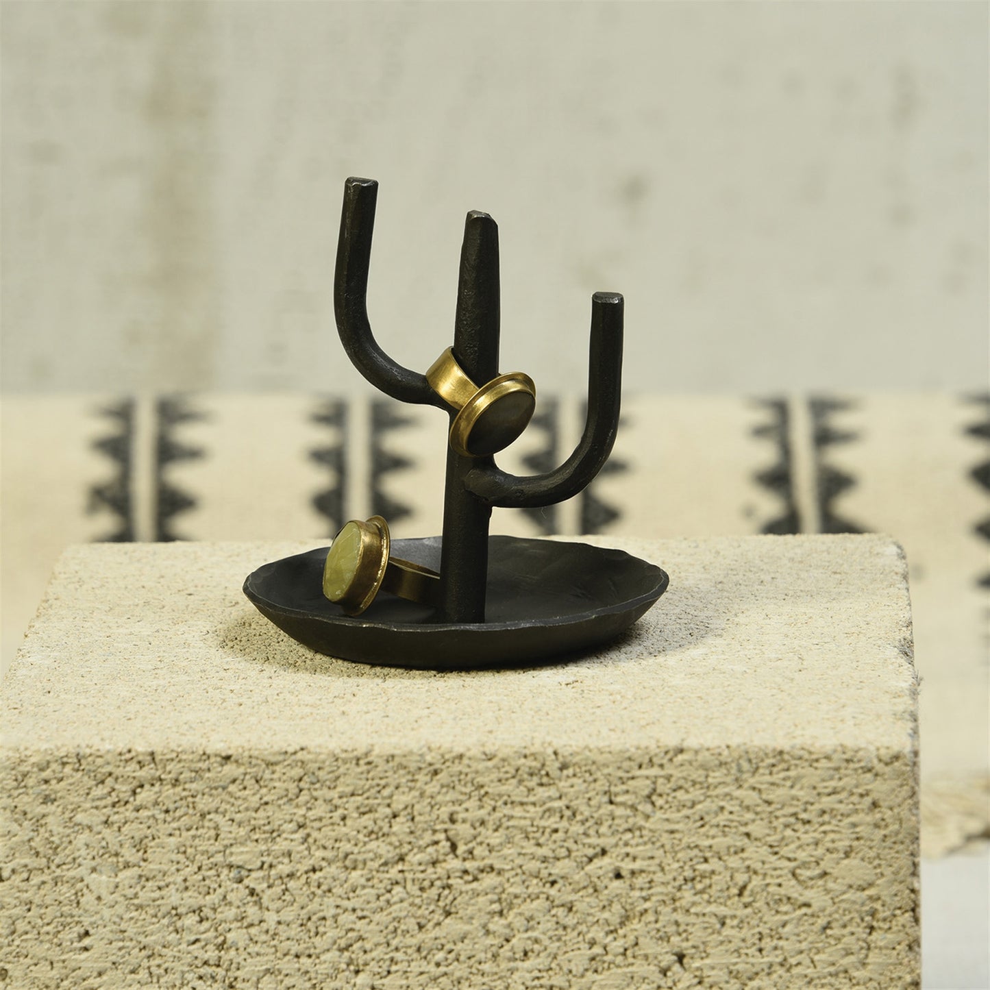 Black cactus ring holder with gold rings on three prongs