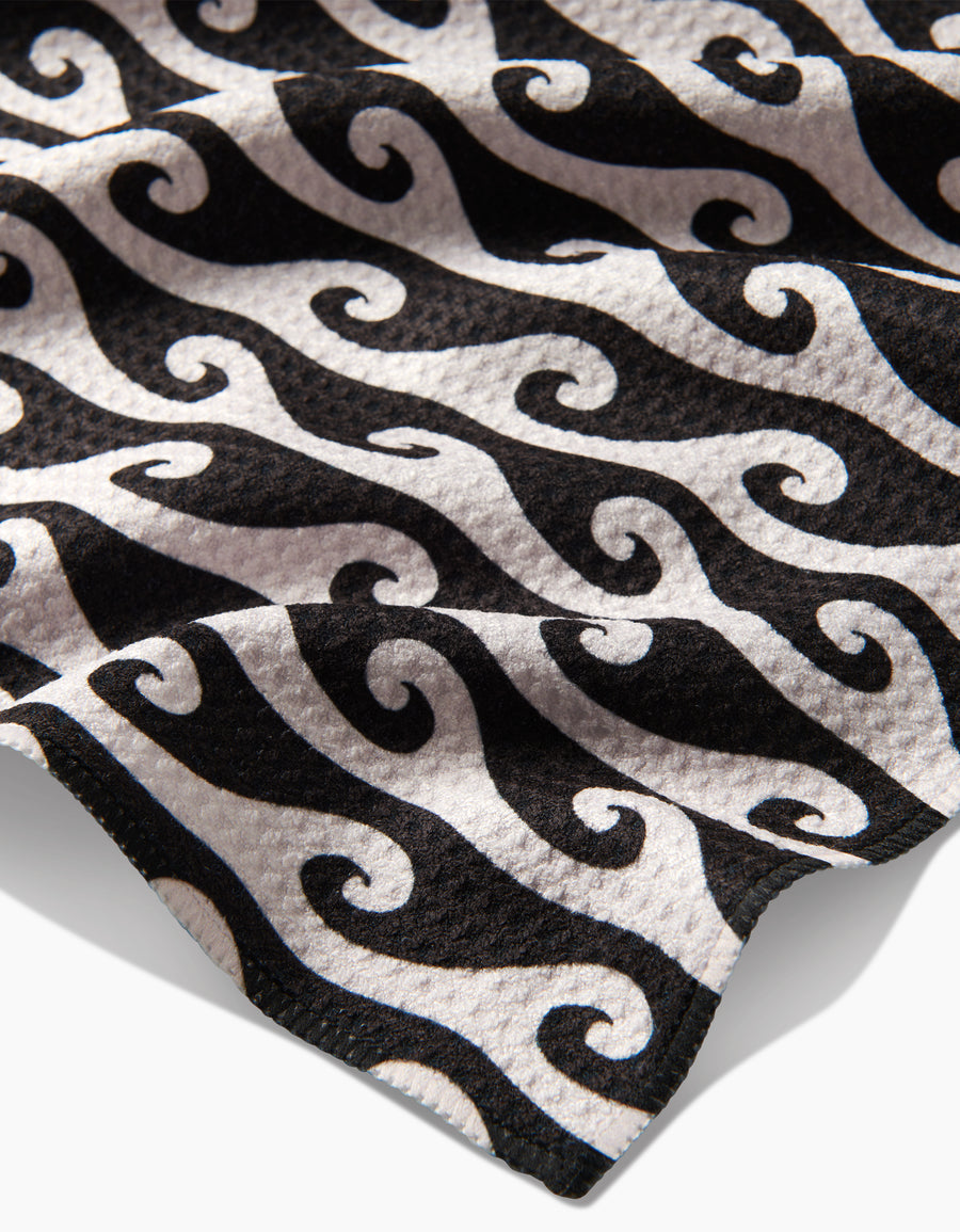 Tea towel fabric with black and white swirl wave pattern and folded edge