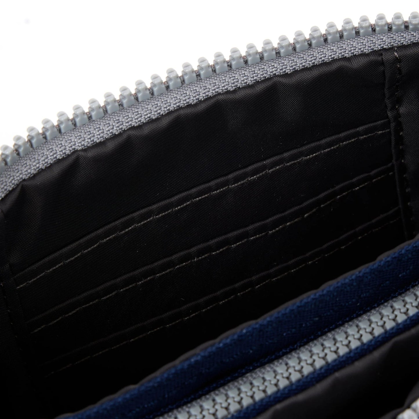 Medium recycled canvas zipper pouch interior close-up with black lining and grey zipper tape.