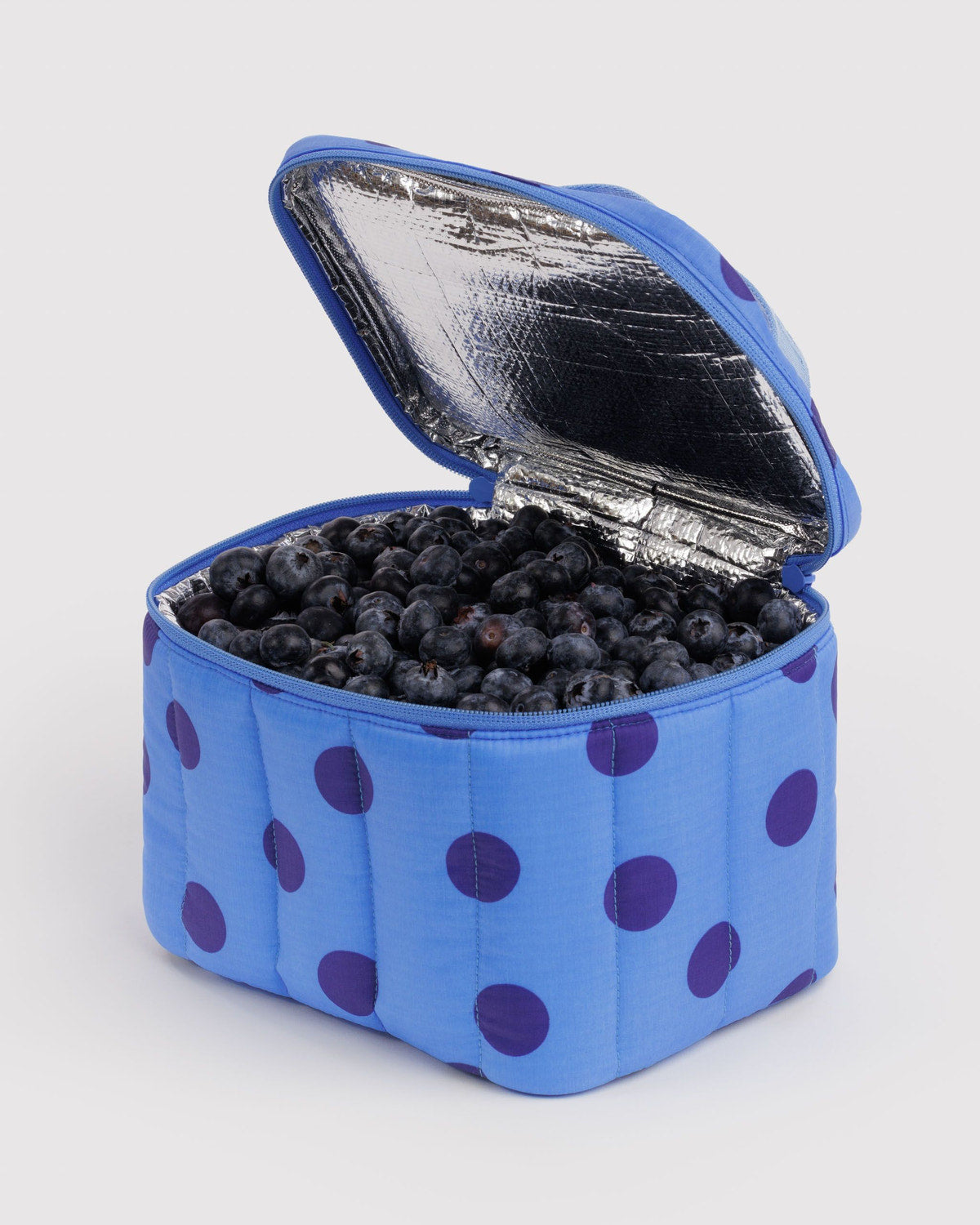 Puffy lunch bag with open foil-lined lid, blue with purple polka dots and blueberries.