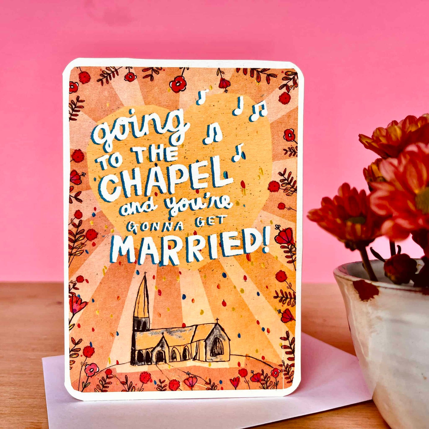 Wedding card showing “Going to the Chapel” text, chapel illustration, and floral border