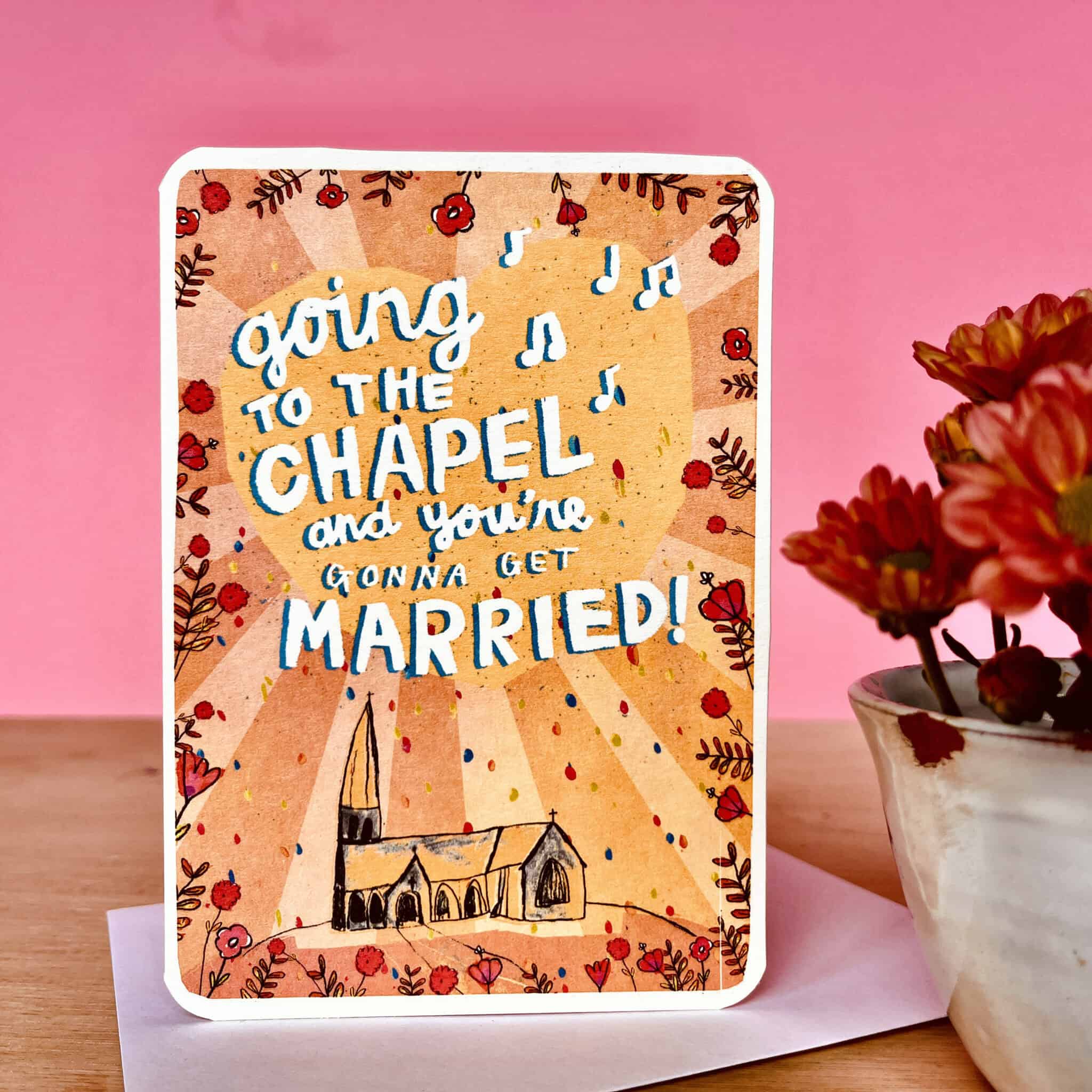 Wedding card showing “Going to the Chapel” text, chapel illustration, and floral border