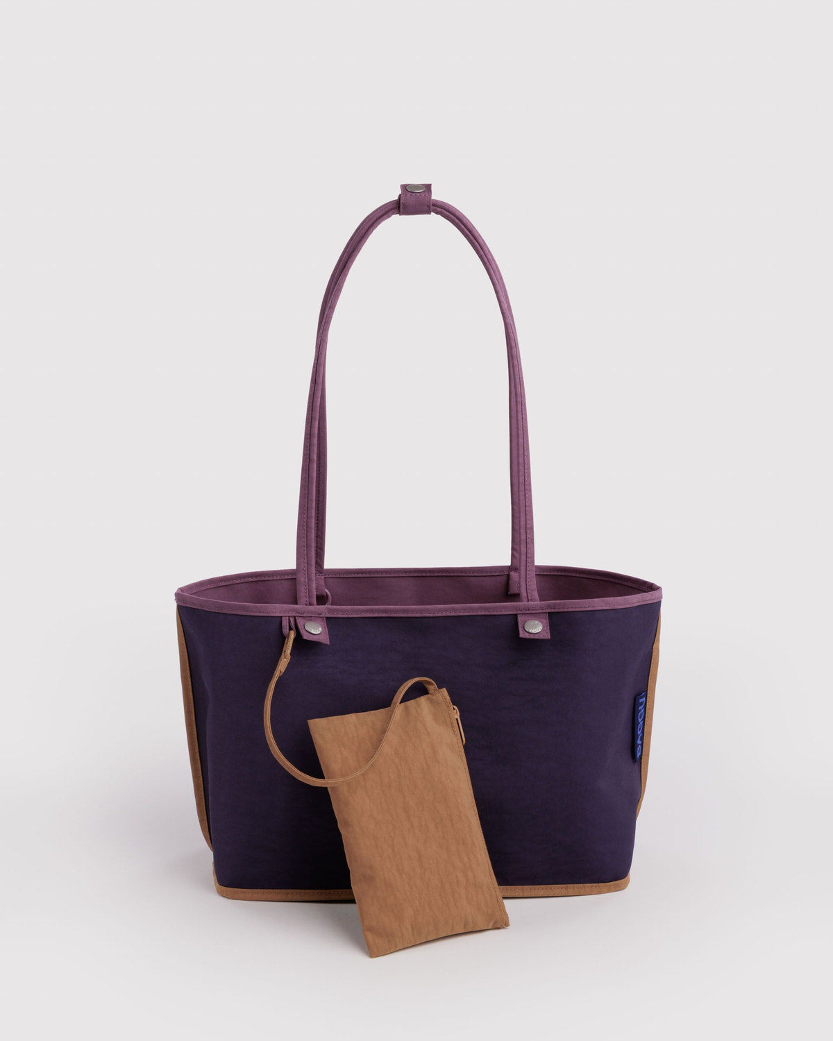 Medium reversible nylon tote with top handles, plum outside and navy inside with tan pouch.