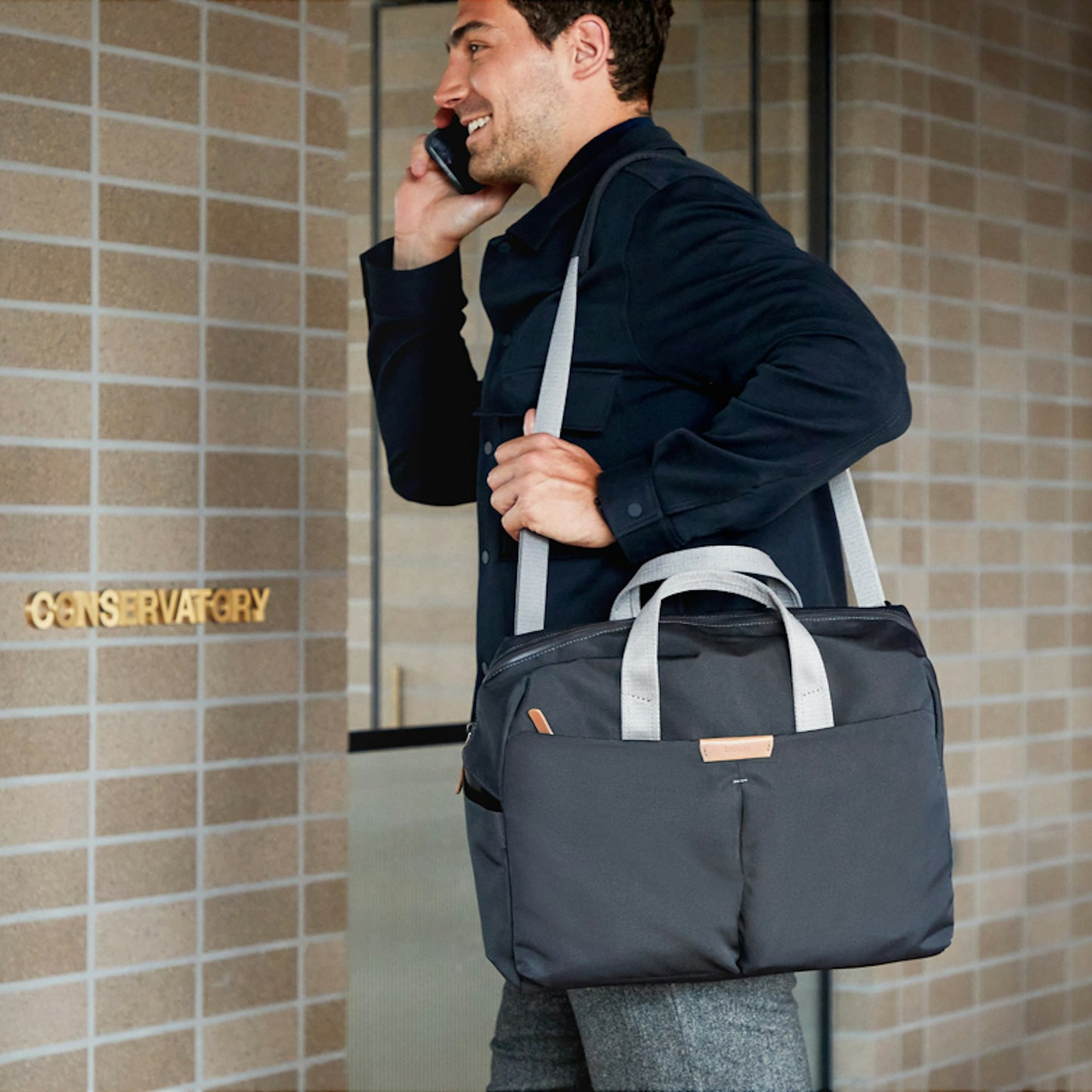 Navy work bag carried over shoulder with top handles and front pocket