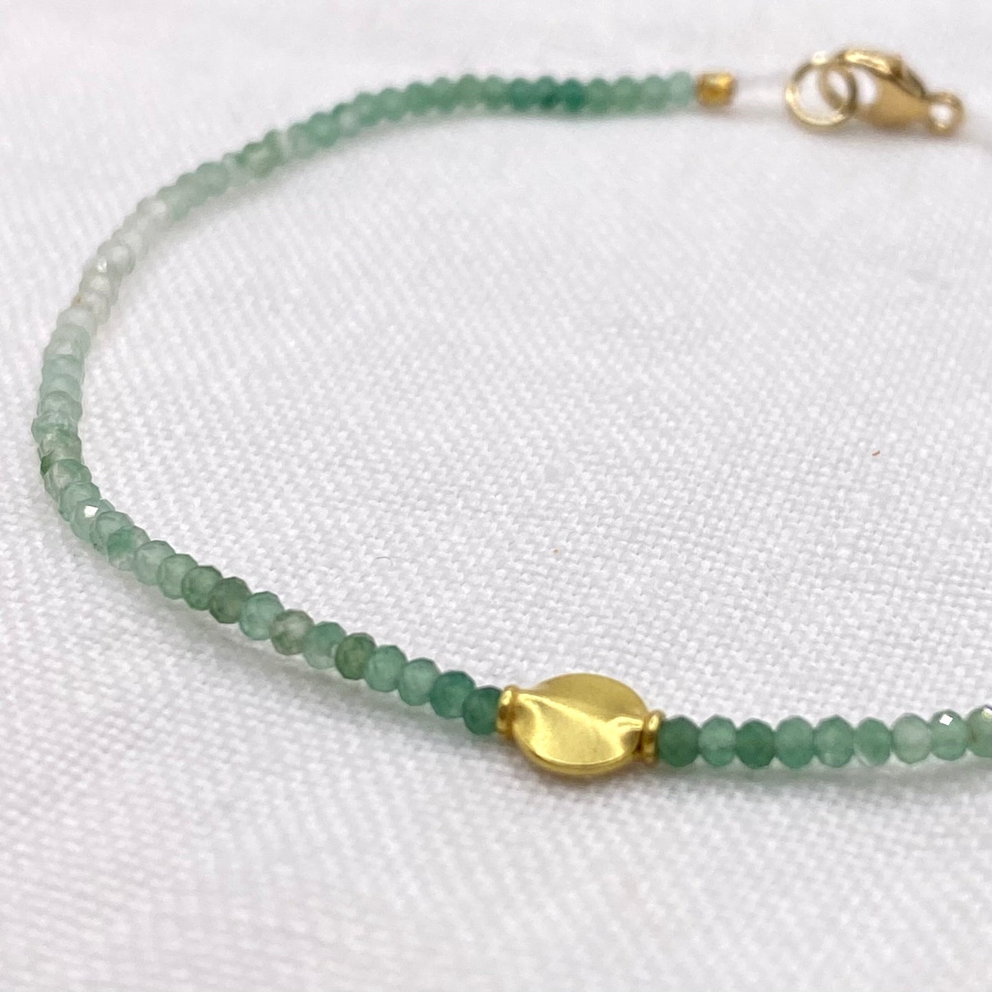 Green aventurine bead bracelet with gold center charm and clasp detail