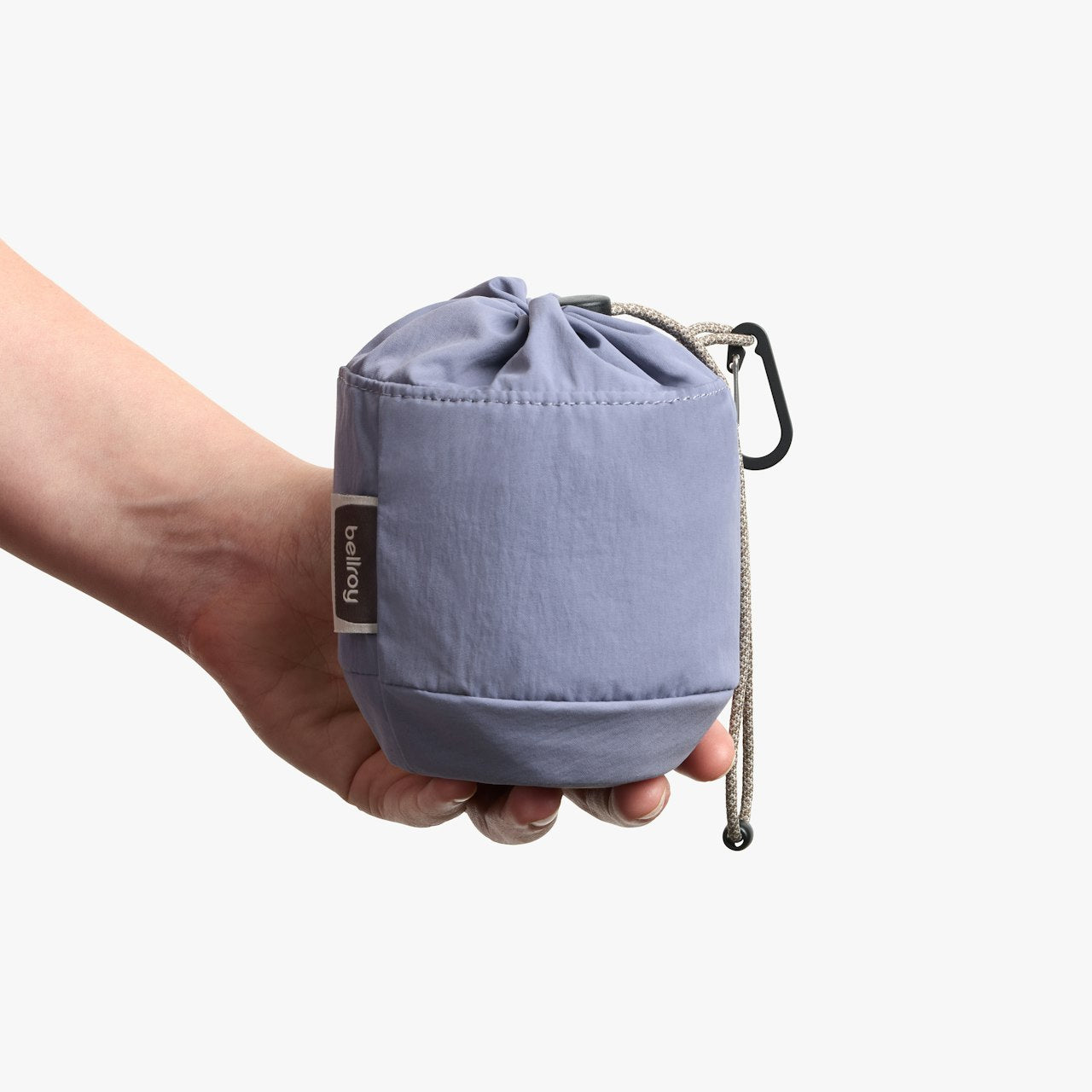 Lilac cinch pouch held in hand, with carabiner clip and braided rope drawcord