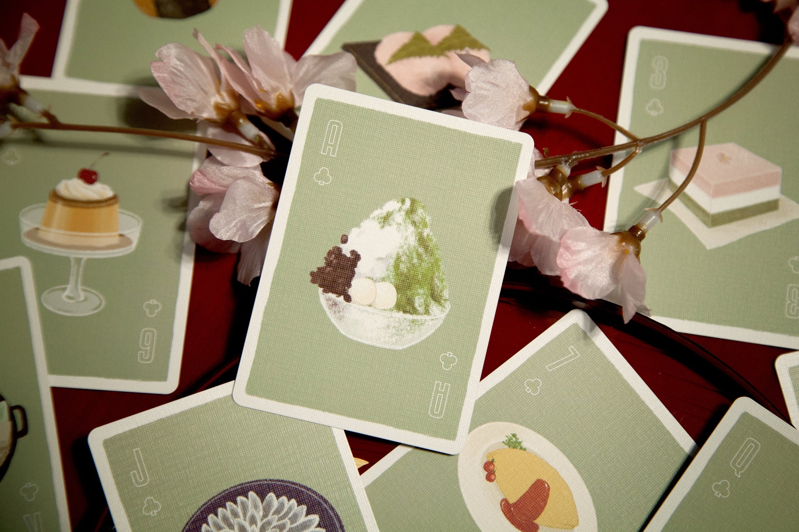 Oishii playing cards with green backs featuring white circle graphic and small icons
