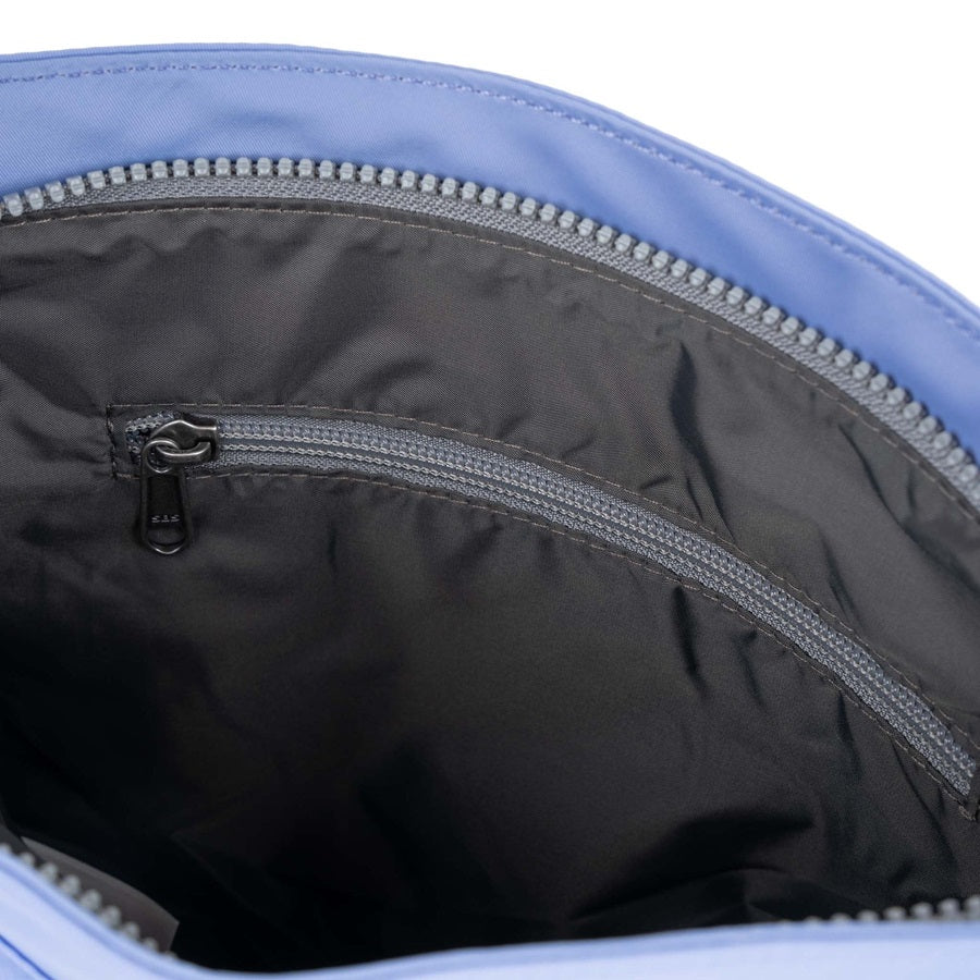 Interior view of light blue nylon crossbody bag with zip pocket and silver zipper hardware