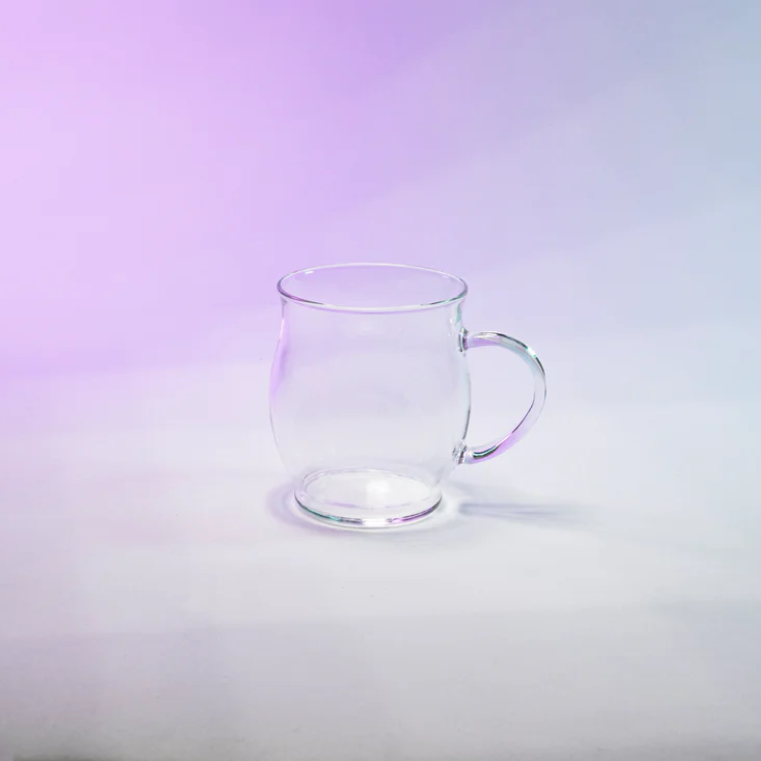 Clear glass mug with wide rim, curved side handle and rounded bottom