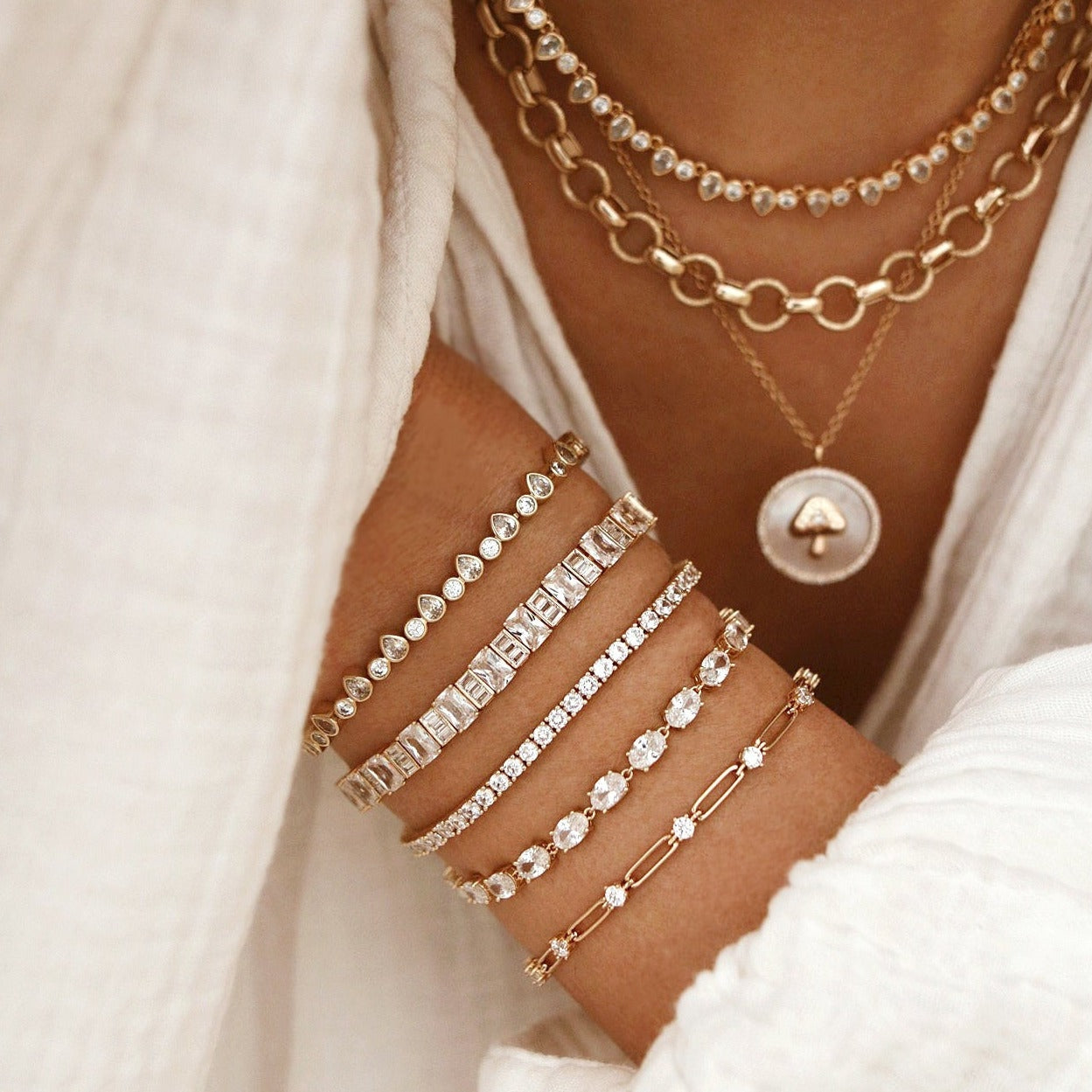 Gold oval tennis bracelet detail with faceted oval clear stones and hinged clasp