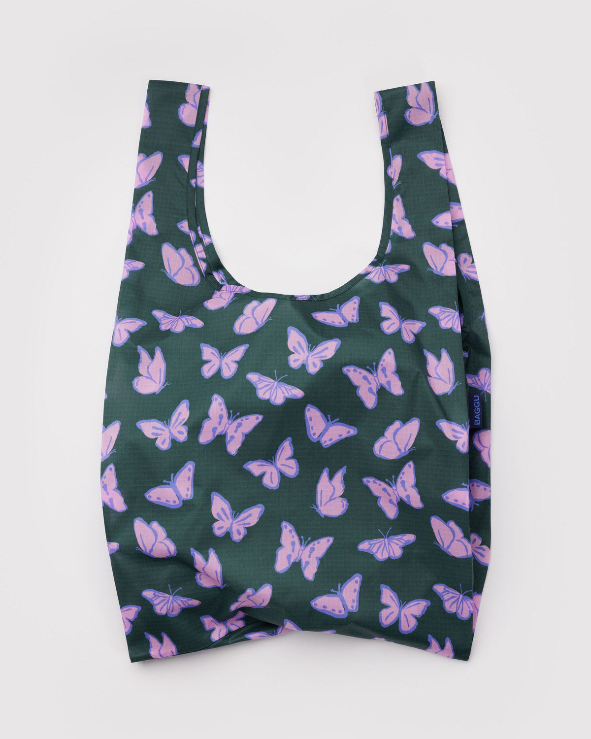 Reusable tote bag in dark green with purple butterfly print and short U-shaped handles.
