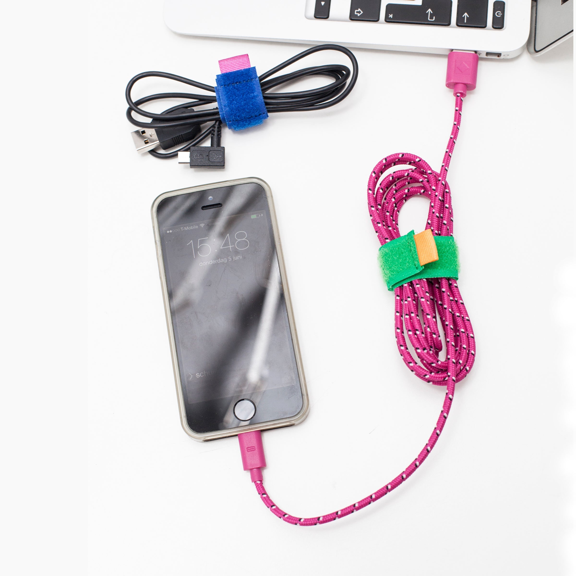 Color cable ties fastening cables to a phone, pink cord with green and blue ties