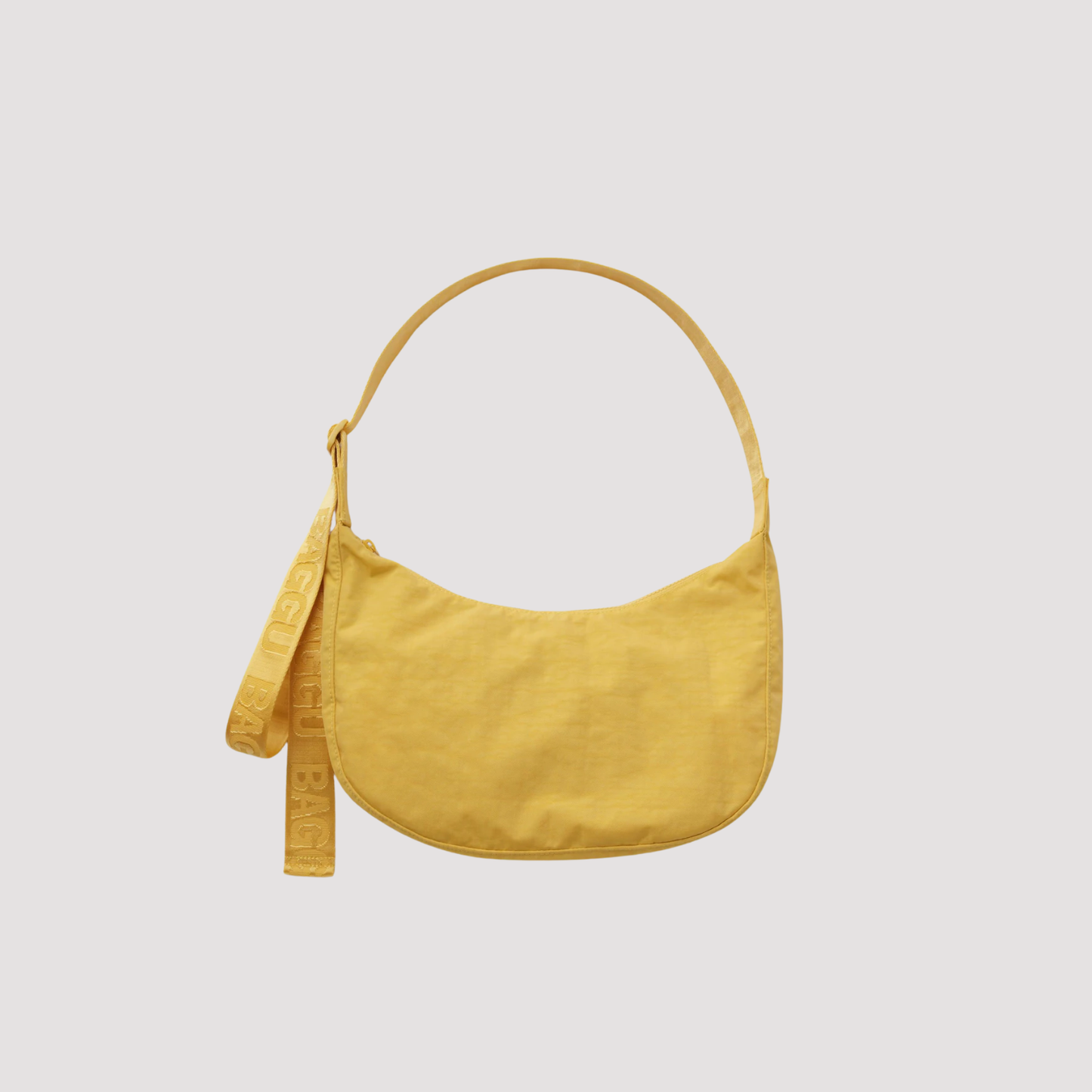 Medium nylon crescent bag in mustard yellow with top handle and dangling strap tag