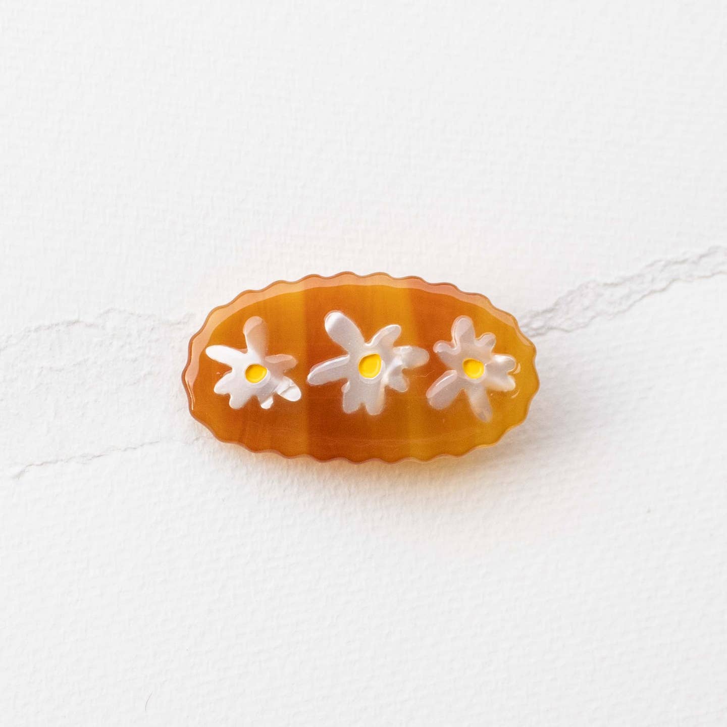 Bronze acetate hair clip with three white daisy appliques
