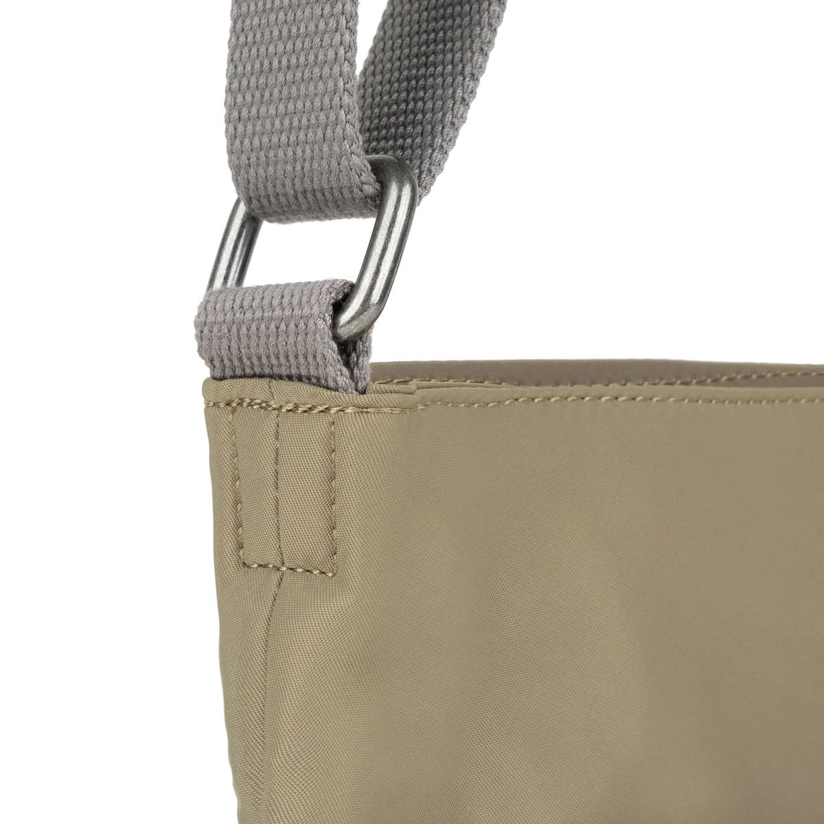 Beige crossbody bag with gray webbing strap and stitched attachment point