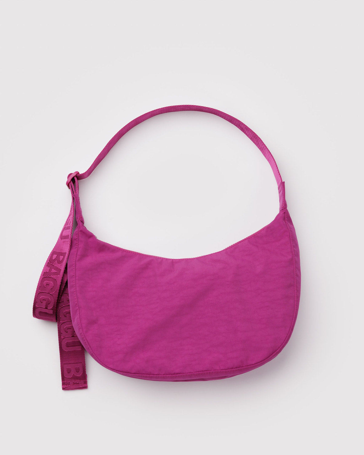 Fuchsia pink nylon crescent bag with long strap and hanging tag