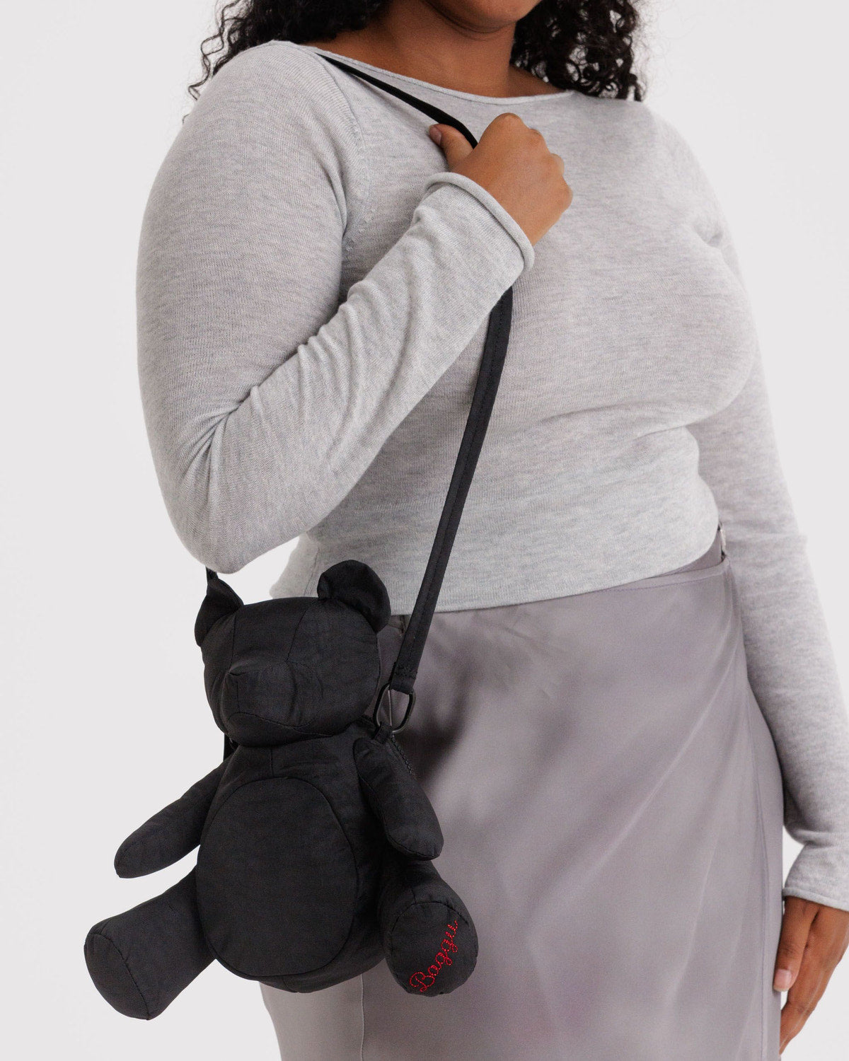 Black plush bear bag worn crossbody, bear face detail and dangling strap