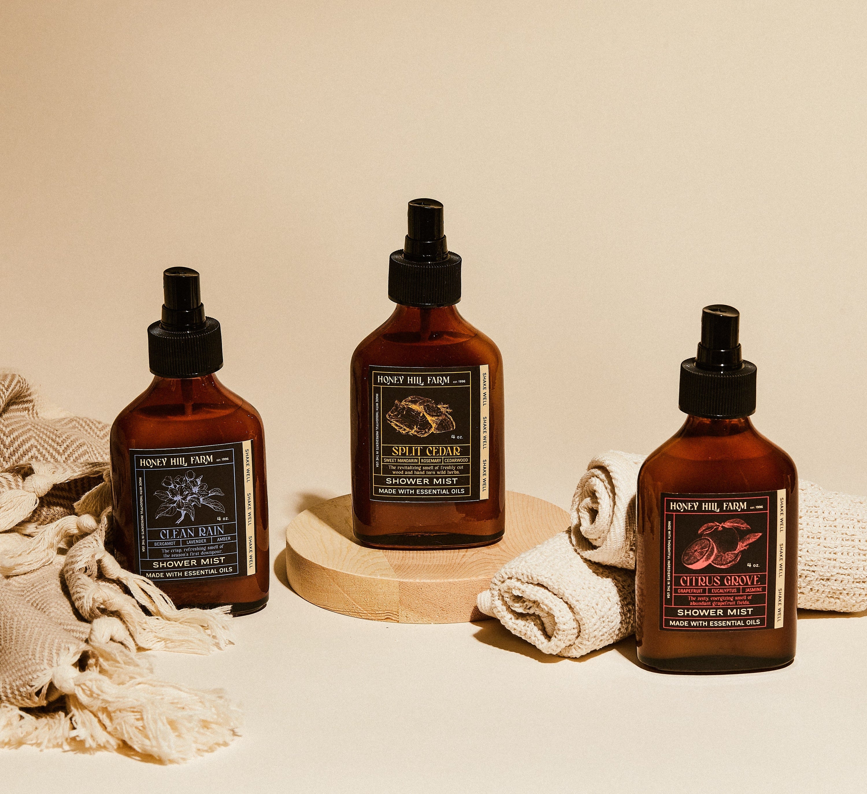 Shower mist spray bottles, amber glass with black pump, three assorted scents.