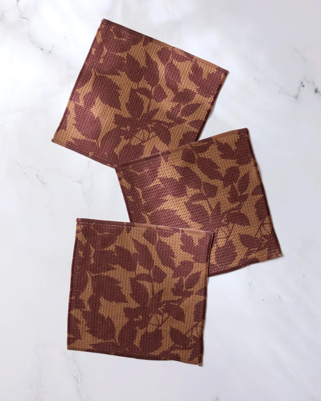 Dishcloth set of 3 in rust brown with leaf pattern, folded and neatly stacked