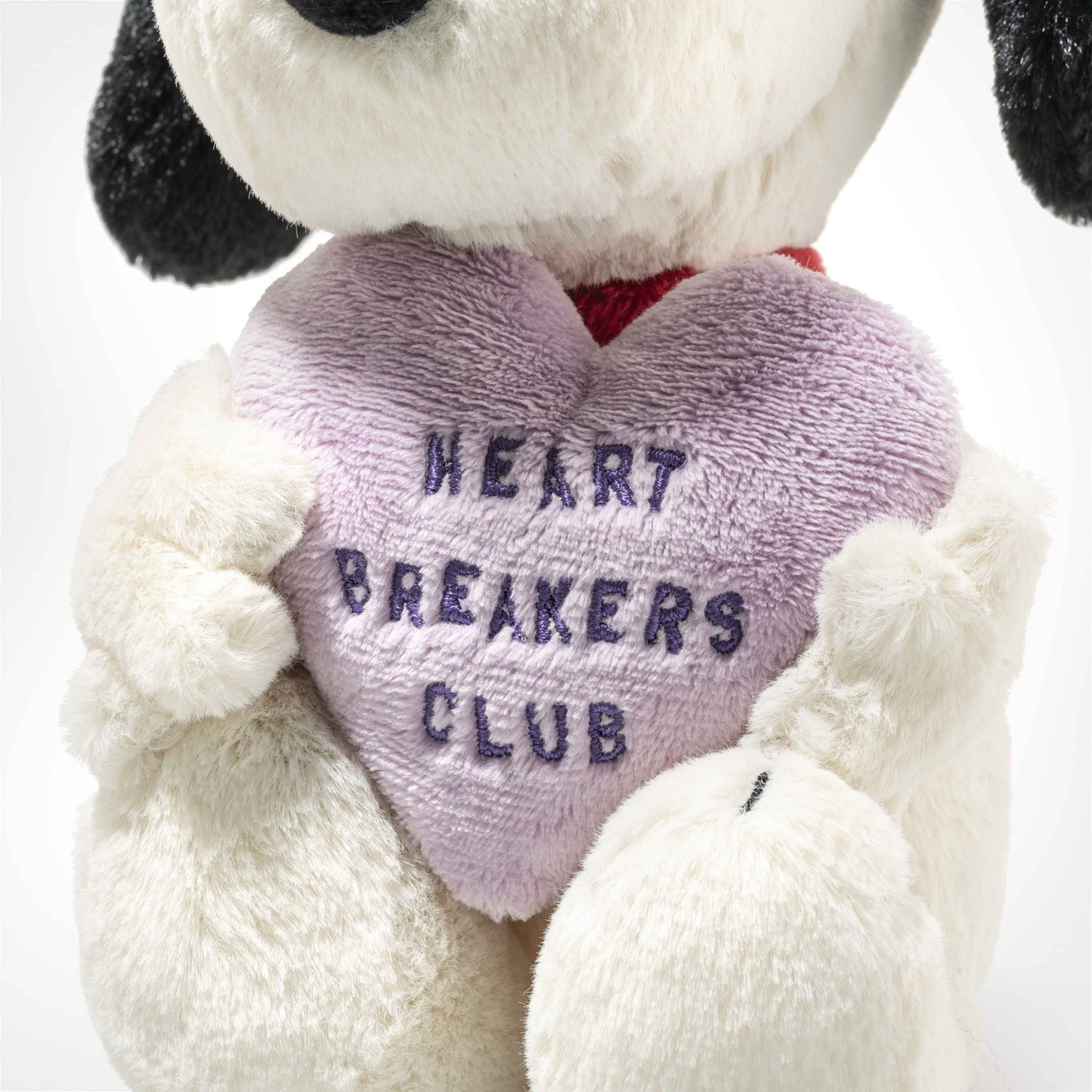 Plush dog toy with purple heart reading HEARTBREAKERS CLUB and red collar