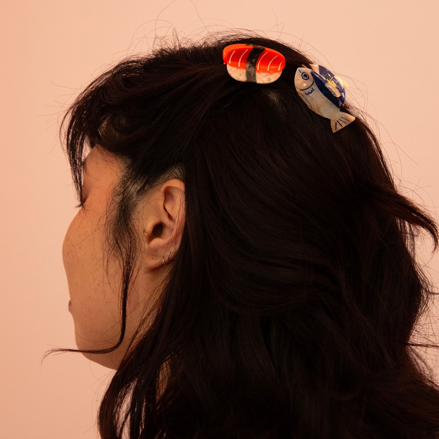 Mini red and white striped claw hair clip on dark hair