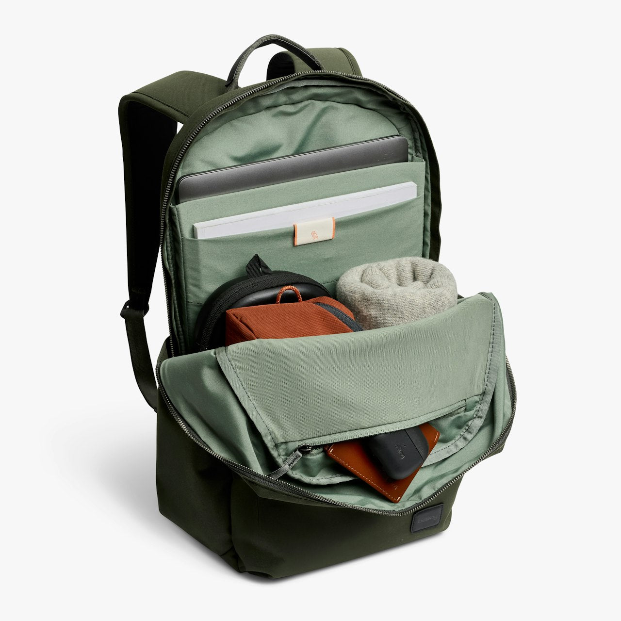Olive daypack open to show interior compartments, zipper pocket, and organizer items