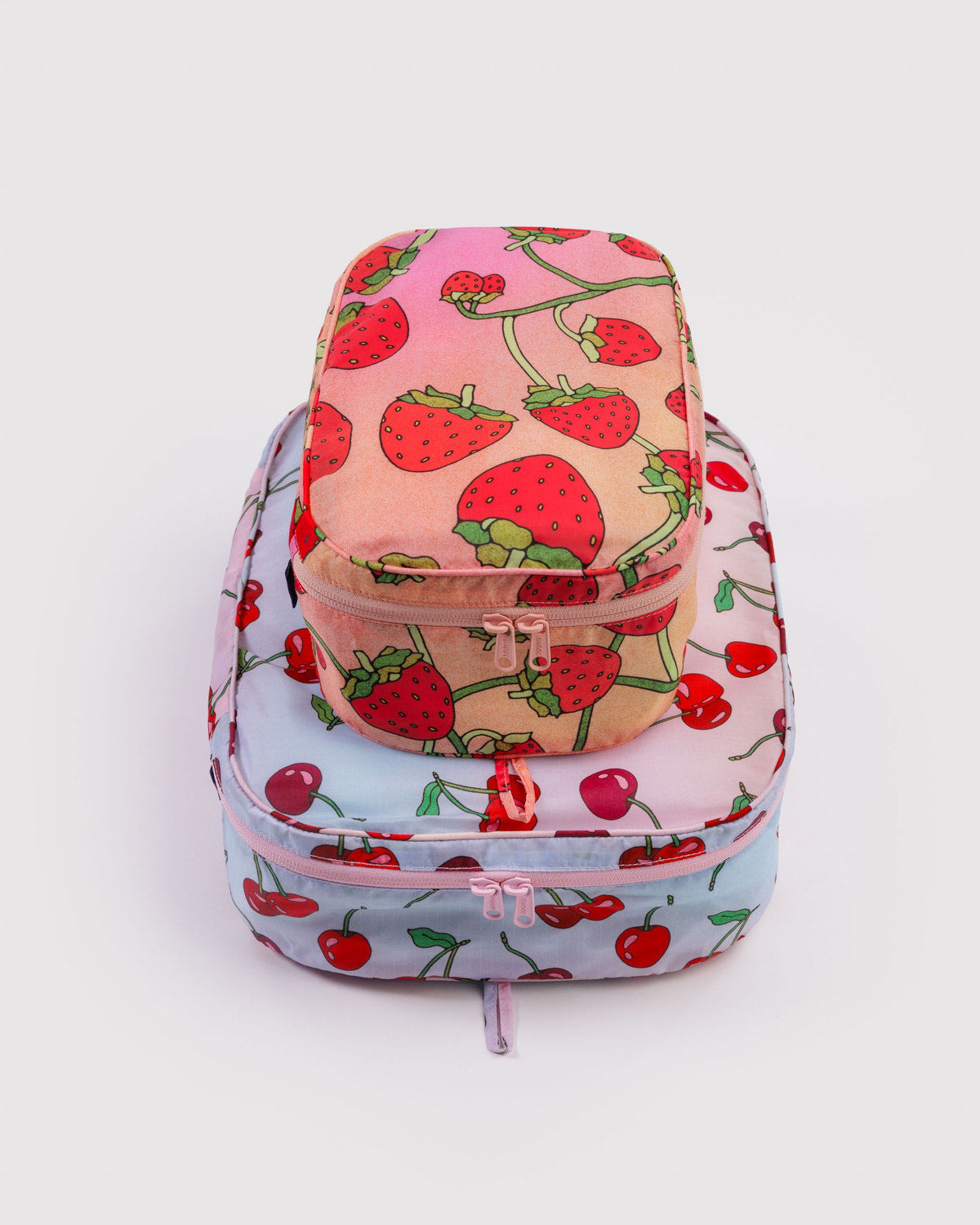 Packing cube set in light pastel red with strawberry print, zip-top closure