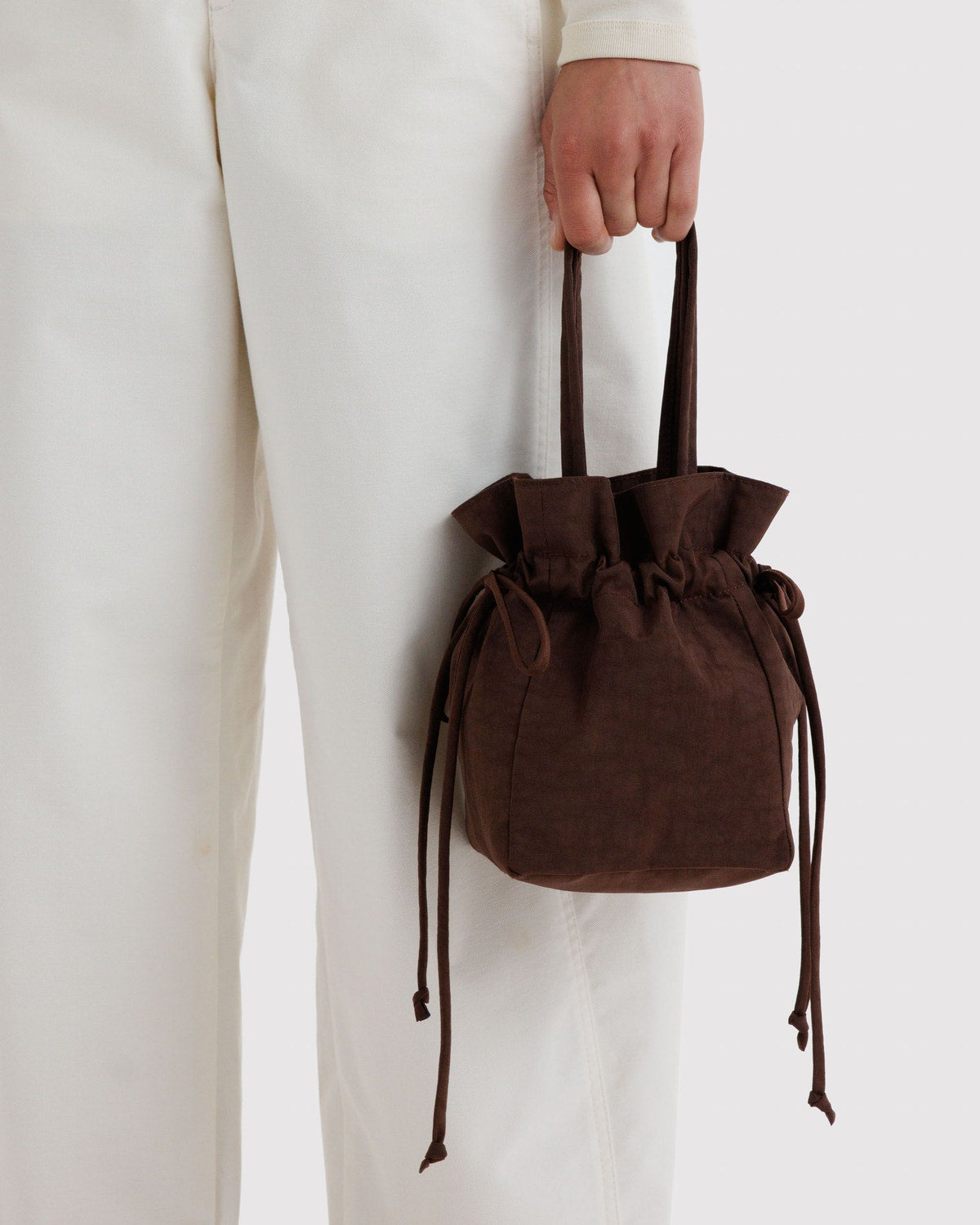Brown nylon drawstring bag with ruched fabric and tied cord ends, handheld