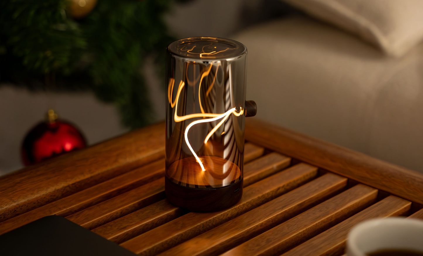 Drift Light glass cylinder lamp with warm flowing filament pattern and walnut base