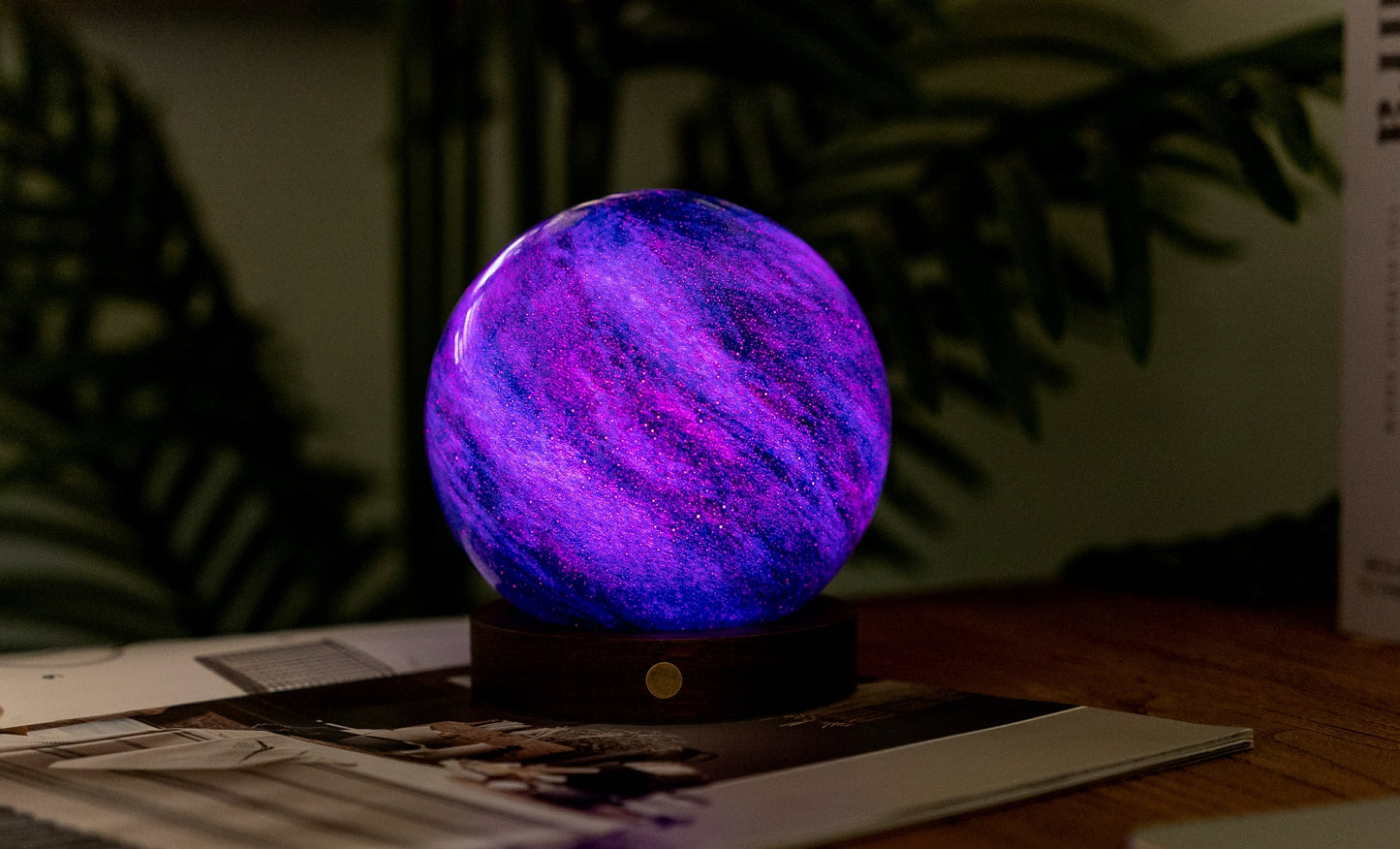 Mini purple galaxy glass globe light with glowing swirl on dark round stand