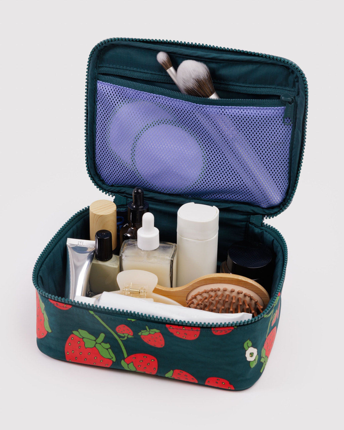 Small cosmetic case, open teal strawberry print with mesh pocket and makeup bottles