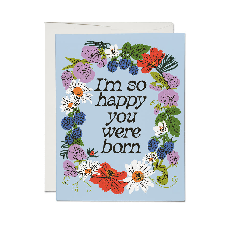 Birthday card with floral wreath and 'I'm so happy you were born' on blue